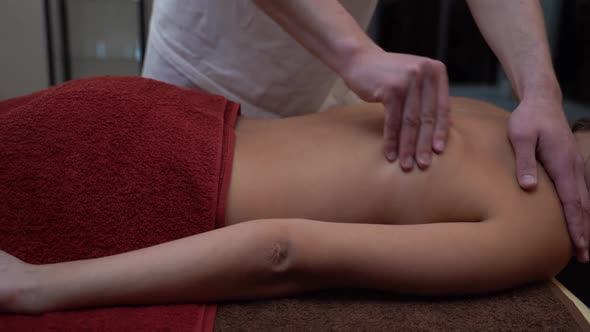 Massage for a Young Tanned Girl in a Spa Room. Close-up