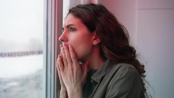 Woman Looks Out of Window at Crime Scene with Police Lights