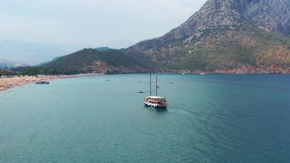 Aerial view of the blue tropical Mediterranean waters Adrasan beach in Turkey as a boat is departing