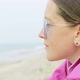 A Girl is Sitting on the Beach and Looking at the Sea - VideoHive Item for Sale