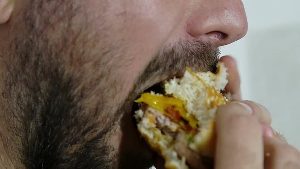 side view of man eating hamburger in slow motion