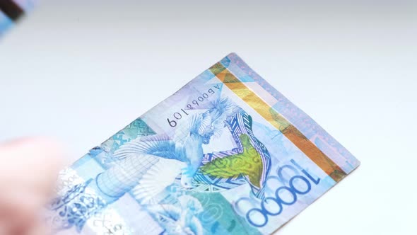 Man counts banknotes Republic of Kazakhstan tenge ten- thousandth and twenty thousandth nominale.