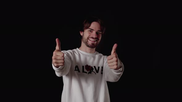 Trendy Young Man giving thumbs up, appreciative gesture, wide, black background