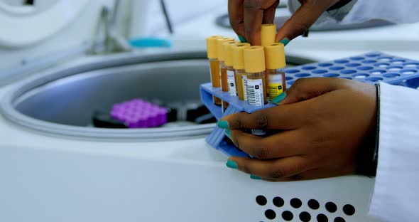 Laboratory technician taking out blood plasma samples from centrifuge 4k