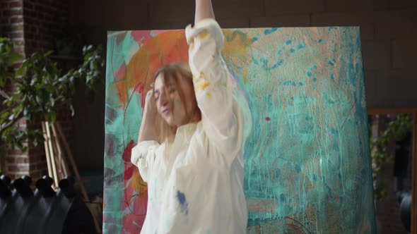 Young Girl Artist Dances Near Her Painting.