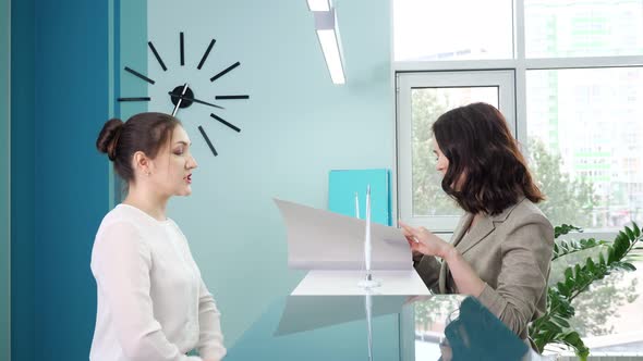 Manager Shows Registration Book to Client at Reception