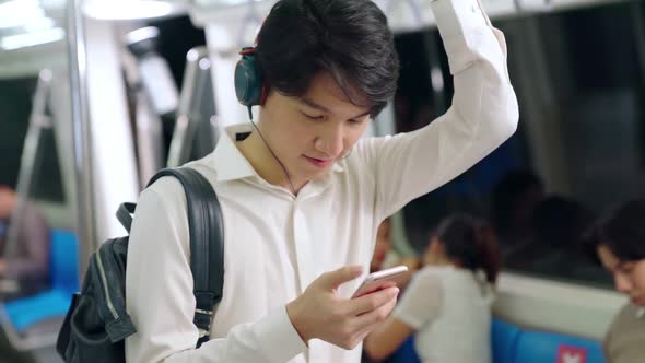 Businessman Using Mobile Phone on Public Train