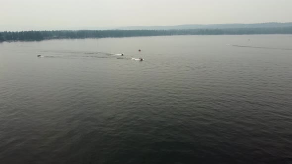 Drone shot of two boats driving to the right of the screen on Lake Payette in McCall, Idaho. This 4K