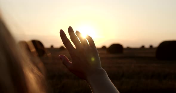 A Woman's Hand Obscures The Setting Sun