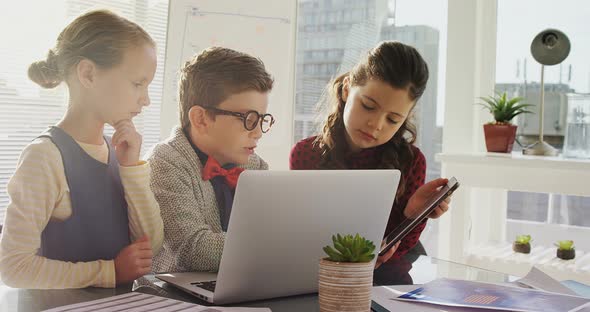 Kids as business executives using laptop and digital tablet 4k