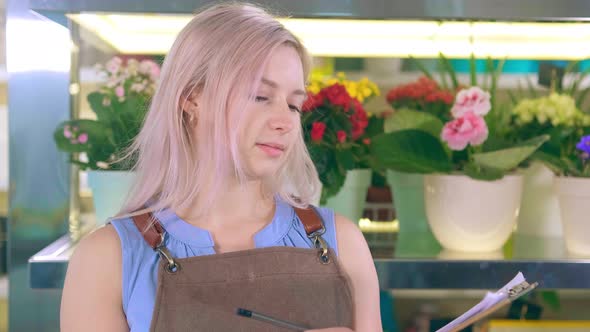 Woman Looks at Camera and Smiles Sincerely Against Flowers