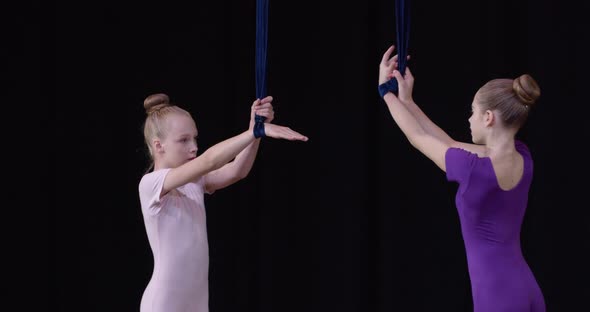 Aerial Gymnasts are Posing and Smiling While Holding the Strings