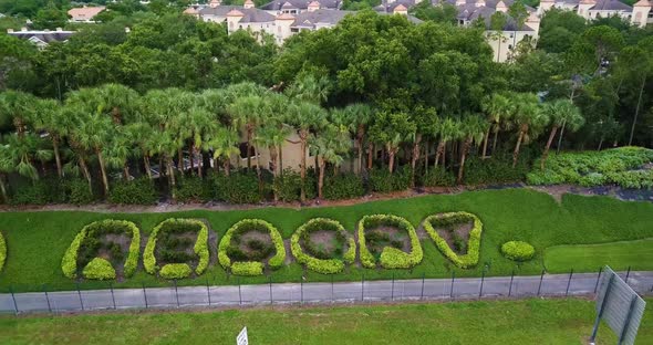 Landscaped Name Of A Resort With Lush Green Trees In A Row In Orlando, Florida. aerial sideways