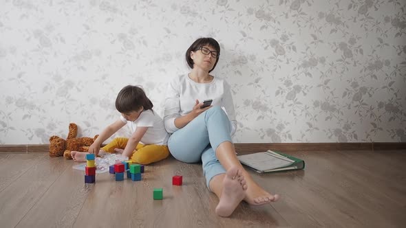 Mom and Son Sit at Home Quarantine Because of Coronavirus COVID19. Mother Works Remotely with