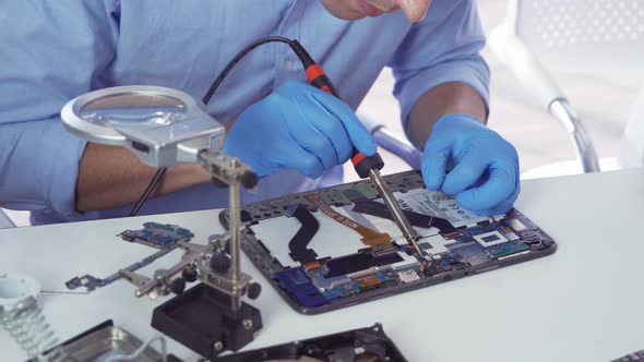 An engineer or technician western man working, examining or repairing computer motherboard