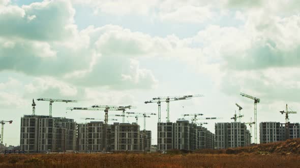 Large construction site with many cranes working over buildings