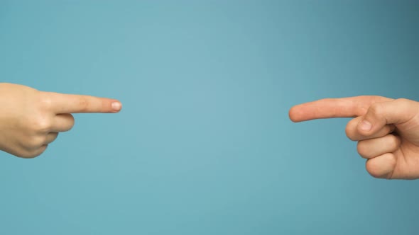 Two human hands touching each other with point fingers isolated on blue background.