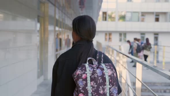 Follow Shot of Afroamerican Schoolgirl with Backpack Walk Outdoors