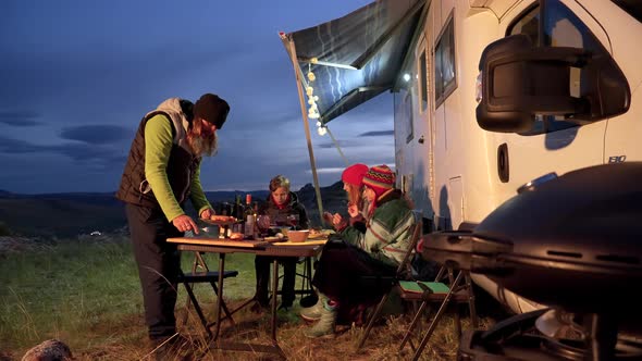 Family Vacation RV Camper Travel with Children Sitting at Table Having Lunch