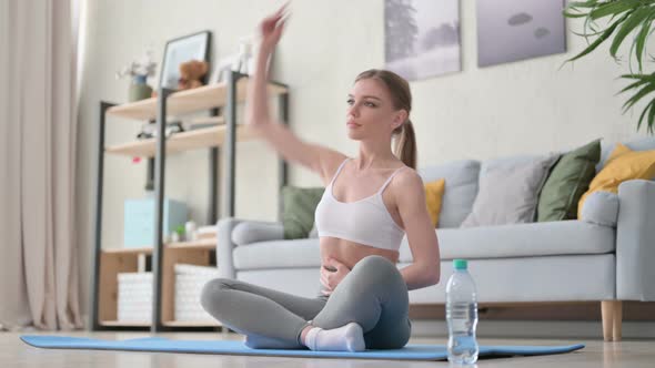 Peaceful Young Woman Meditating on Yoga Mat at Home