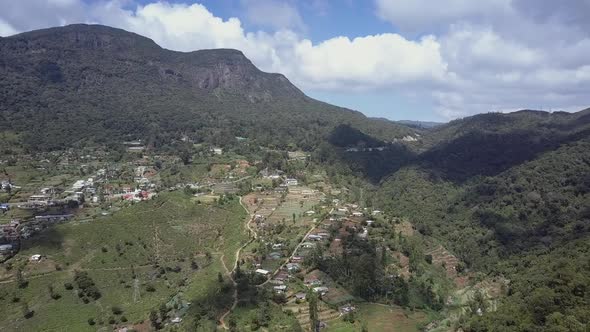 Highland with Green Plantations Small Houses and Serpentine