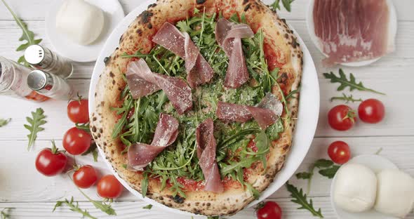 Delicious Pizza with Prosciutto Parma Ham Arugula Salad Rocket with Ingredients