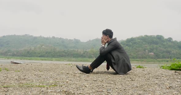 Disappointed Businessman Sitting Near River