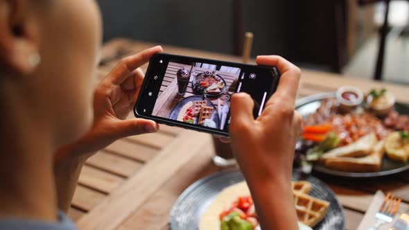 Young Woman Taking Photo of Healthy Breakfast Using Mobile Phone in Vegan Restaurant, Slowmotion