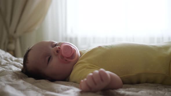 Closeup of a Sleeping Baby with a Pacifier in Mouth