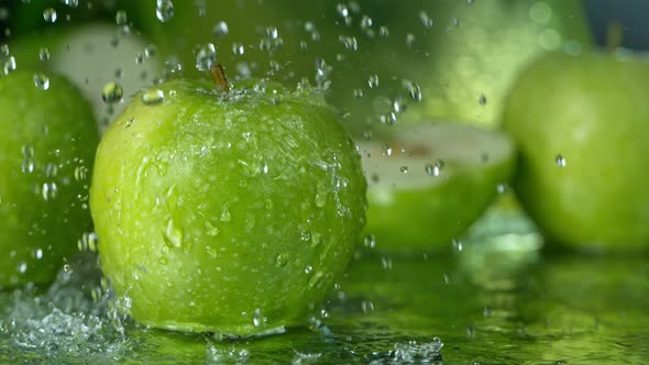 Super Slow Motion Shot of Water Splashing on Fresh Green Apple at 1000Fps