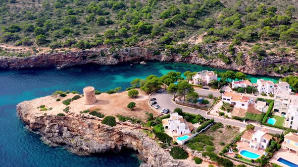 Tower of Torrent de Cala Pi on the Mallorca Spain island coast, Aerial orbit left shot