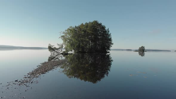 Moving forward to a small island over calm water  on a still sunny morning.