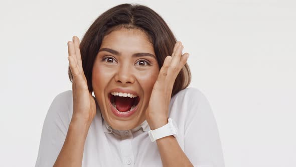 Young Beautiful East Asian Female in Shirt Actively Laughing Smiling in Amazement on White