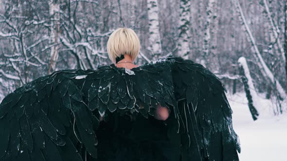 Actress in Wonderful Phoenix Suit Walks Along Winter Forest