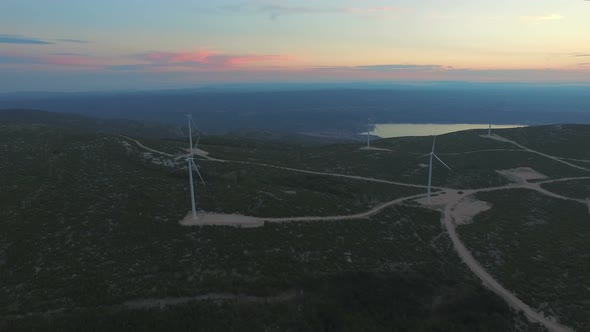 Aerial view of five windmills for the production of electric energy, at sunset