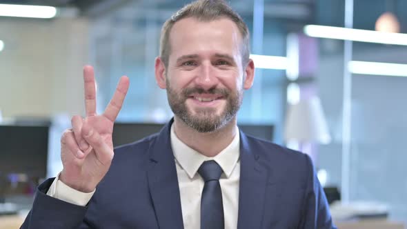 Portrait of Young Businessman Showing Victory Sign