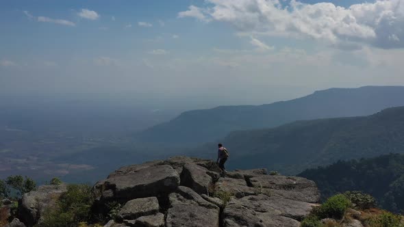 Drone view Young hiking man walking to peak of mountain