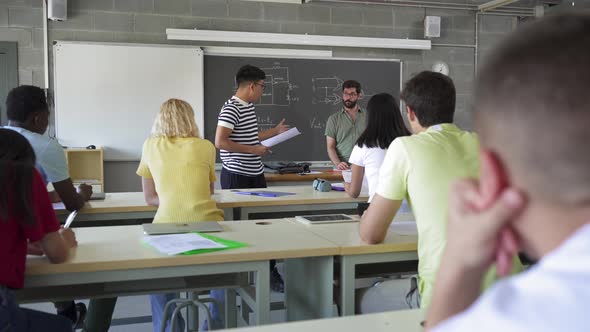 Latin American College Student Presenting a Project Reading a Composition to Classmates and Teacher