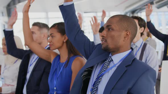 Audience at a seminar raising hands to ask questions