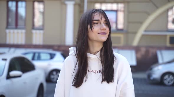 Young, attractive girl walks down the street, dressed in a casual style