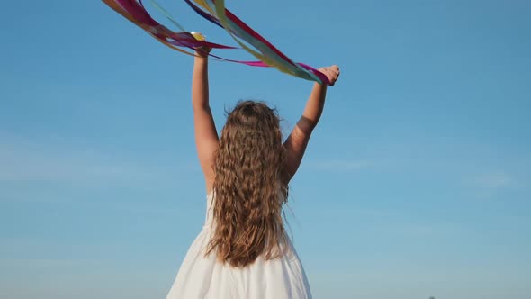 Colorful Ribbons Flying in the Wind in Girl Hands