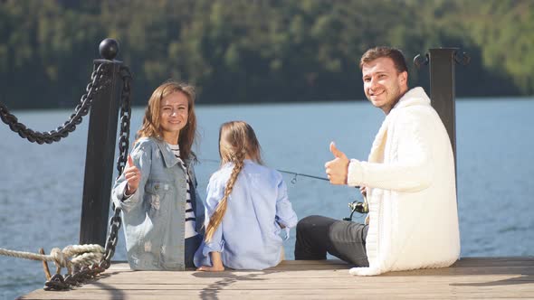 Family with daughter vacation together on sailboat in lake