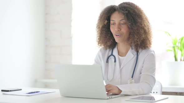 Afrcian Doctor Talking on Video Call on Laptop in Clinic