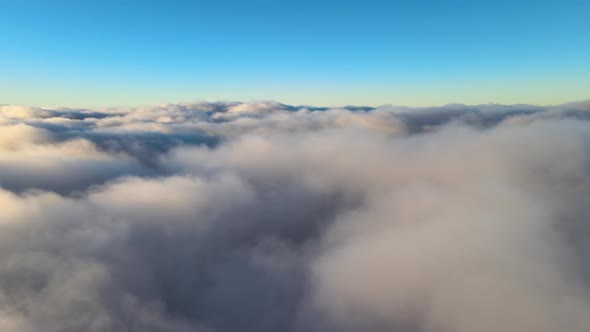 Aerial View From Above at High Altitude of Dense Puffy Cumulus Clouds Flying in Evening