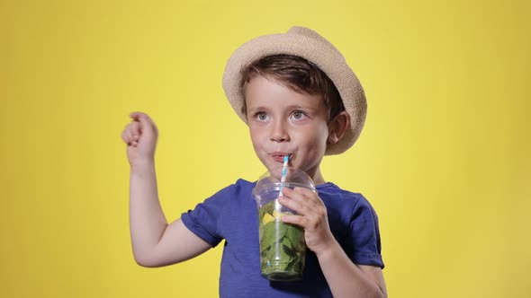 Cute boy Drinking Mojito cocktail From Plastic Cup. Summer, vacation, sun, heat, sea, beach.