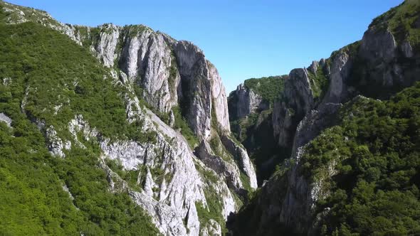 Fantastic view into the narrow and deep Turda Gorge near Transylvania. Sheer rock cliffs cut by the