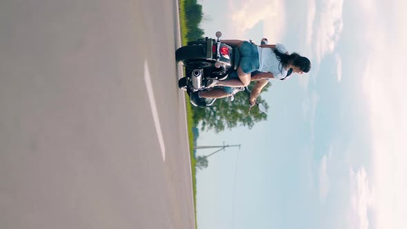 Young Man and Woman Ride Black Motorcycle