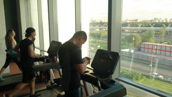 Sports People Running on Treadmills in a Gym Near Huge Panoramic Window