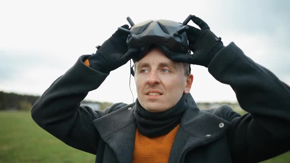 Serious Man Puts on Black FPV Drone Goggles Outdoors