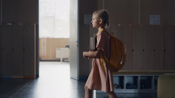 Schoolgirl Walking Holding Books in Empty Hall Alone